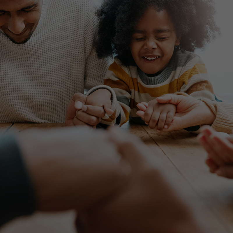 Banner for the Pastor Jenkins devotional, "5 Ways You Can Raise Your Children to Hear and Follow God's Voice": Image shows an adult holding a child's hand while reading a book or Bible.